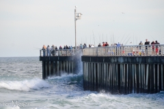 Lots of people fishing on the pier.